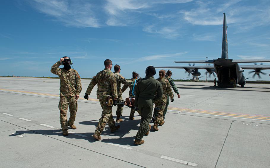 American and Polish service members carry a pretend patient to a C-130 Hercules on June 6, 2023, at Mihail Kogalniceanu Air Base in Romania. Military medical teams from the U.S. and Poland collaborated in patient care scenarios as part of exercise Saber Guardian.