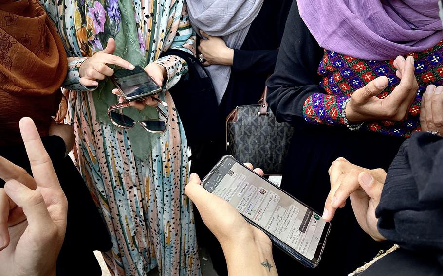 Female protesters compare messages from other groups marching in the Afghan capital as they decide how to move forward. 