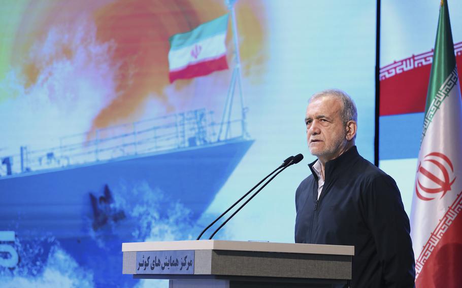 Iran President speaking behind a podium.