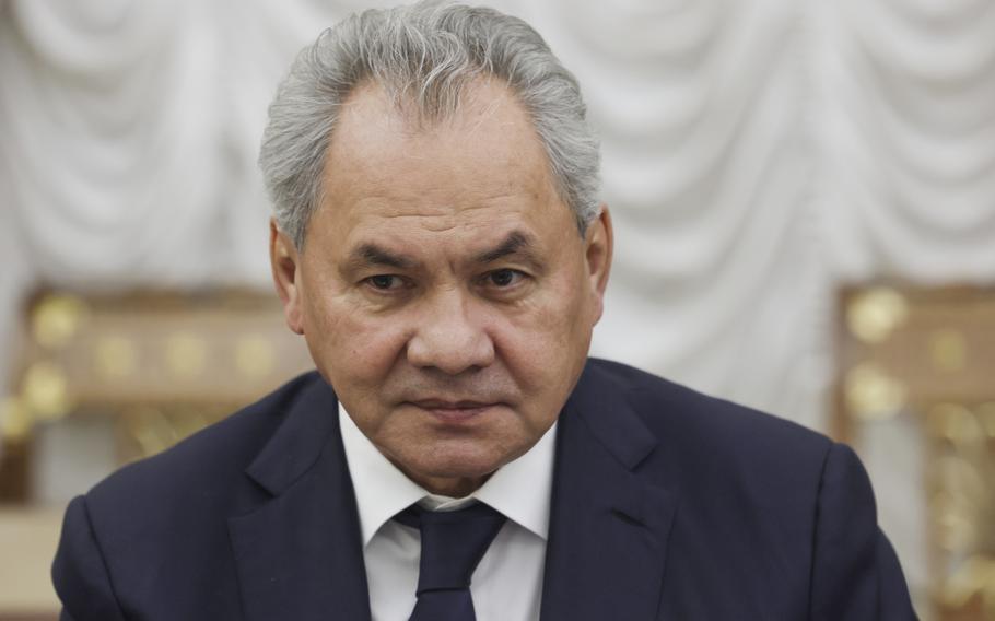 Russian Security Council Secretary Sergei Shoigu wearing a black suit listens during a meeting.