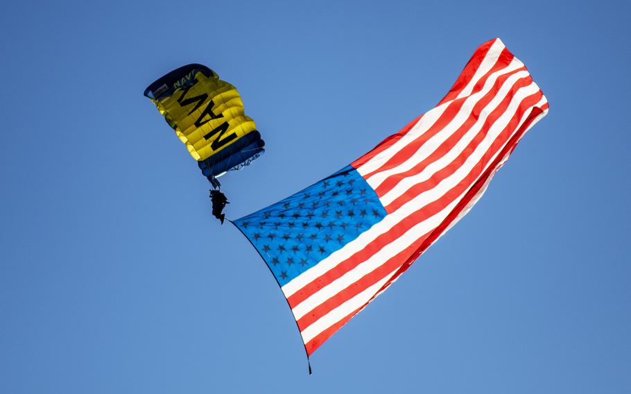A Navy parachutists with an American flag trailing behind performs prior to the start of the 123rd Army-Navy football game on Dec. 10, 2022, in Philadelphia. A memo issued Feb. 10, 2023, from the Defense Department’s public affairs office is prohibiting the use by service members of giant U.S. flags during sporting events and parachute jumps.