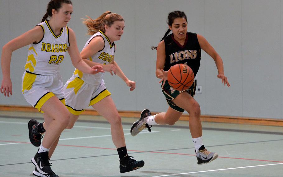 AFNORTH’s Selah Skariah drives the ball up court against Alconbury’s Sally Messimer, left, and Paige Sander in a Division III game at the DODEA-Europe basketball championships in Baumholder, Germany, Feb. 16, 2023. The Lions won the game 38-18.