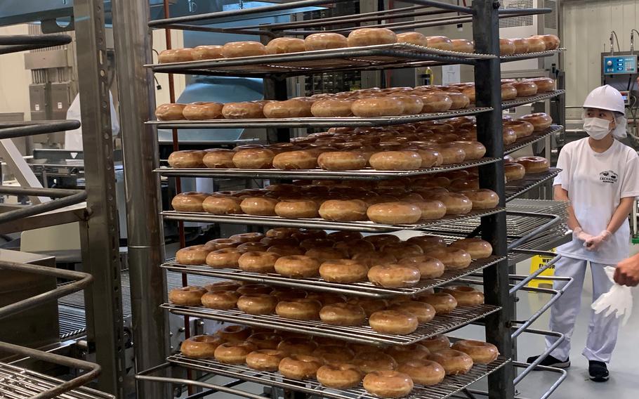Fresh Krispy Kreme doughnuts are placed on racks inside a new Army and Air Force Exchange Service bakery at Camp Humphreys, South Korea, Friday, Nov. 19, 2021.