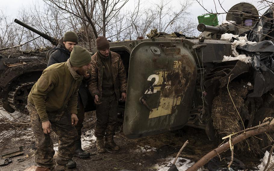 Sasha, left, and other Ukrainian soldiers work to repair their broken down armored personnel carriers on the outskirts of Vuhledar on Thursday, Feb. 2, 2023.