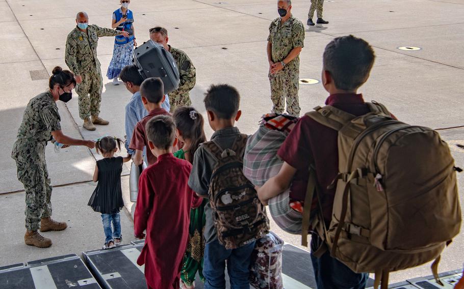 Sailors stationed at Naval Station Rota, Spain, greet evacuees from Afghanistan after their arrival at the base aboard a U.S. Air Force C-17 Globemaster III, Sep. 1, 2021.