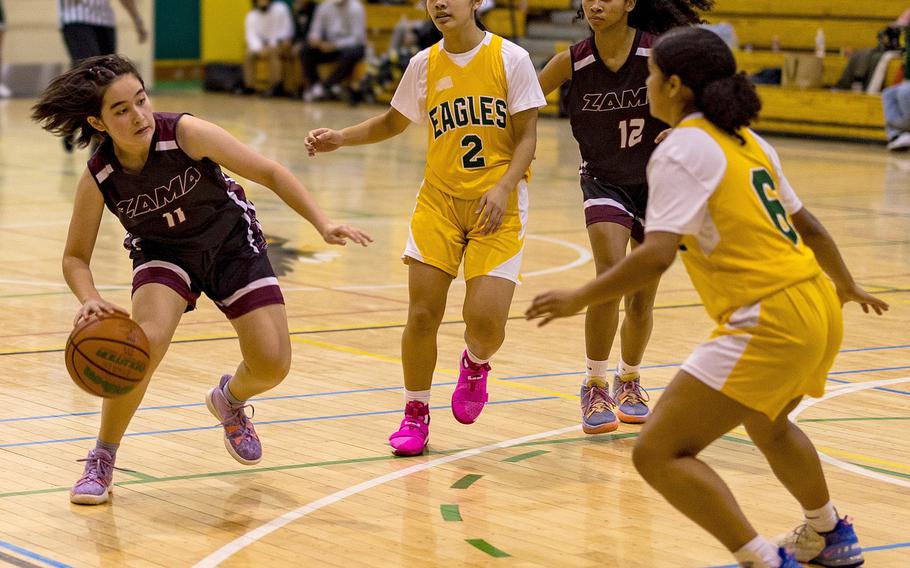 Zama's Lindsey So dribbles against Robert D. Edgren's Annalise Tackney and Zalea Washington as Trojans teammate Madison Anderson looks to help during Friday's DODEA-Japan girls basketball game. The Eagles won 35-23. 