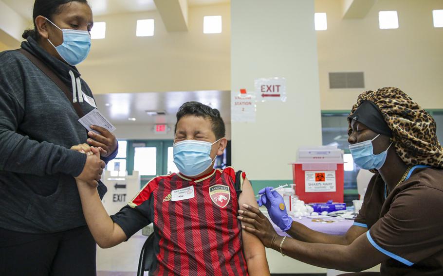 Christiana Neri, 38, holds her 13-year-old son Ivan Hernandez as Sequoia Hutton administers the Pfizer COVID-19 vaccine at a mobile vaccine clinic held for people age 12 and over at Roosevelt Park on Friday, May 14, 2021, in Los Angeles.