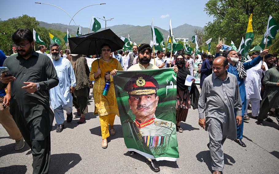 A man carries a portrait of Pakistani Army Chief General Syed Asim Munir during a rally.