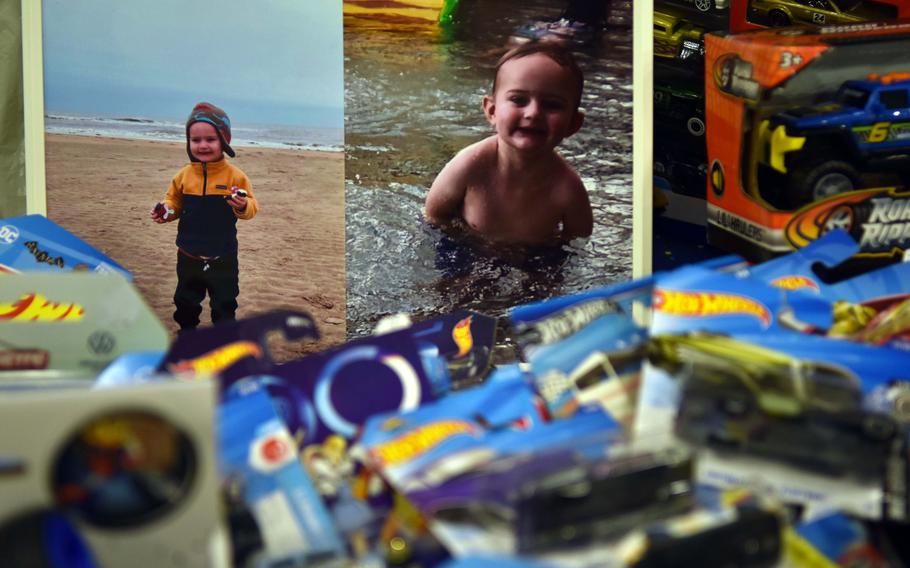 Photos of toddler Caleb Anders in a jacket and hat on the beach and in the swimming pool are surrounded by Hot Wheels cars. 