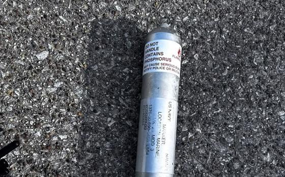 A metal canister of phosphorous pyrotechnic is seen on the ground.
