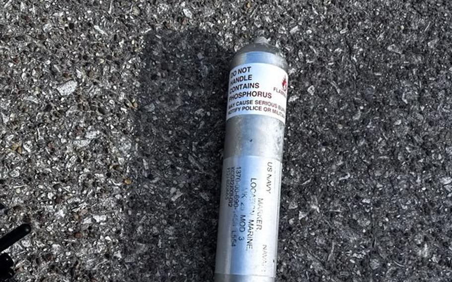 A metal canister of phosphorous pyrotechnic is seen on the ground.