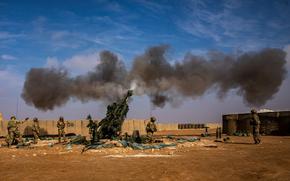 Smoke rises after soldiers fire a M777 Howitzer.