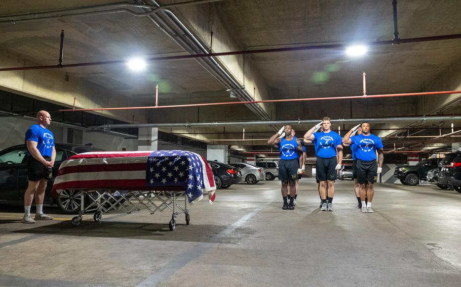 Marine salute next to a coffin draped in an American flag
