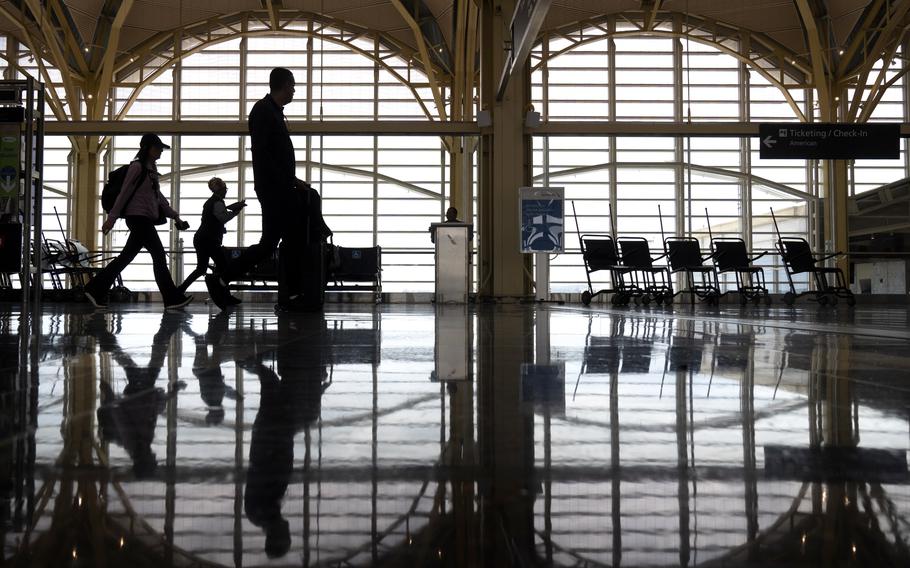 Travelers walk along a concourse.