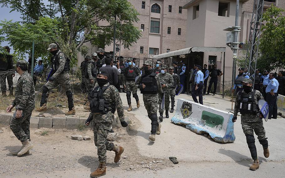 Paramilitary troops and police officers stand guard outside a court where Pakistan’s former Prime Minister Imran Khan appeared in Islamabad, Pakistan, Tuesday, May 23, 2023. 