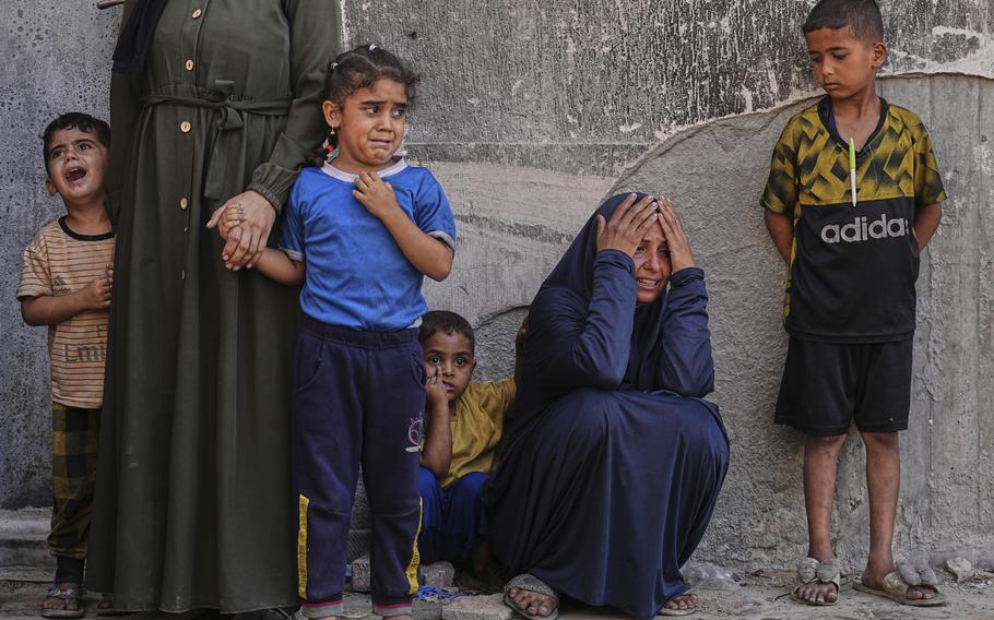 Palestinians, including children, stand outside a hospital.