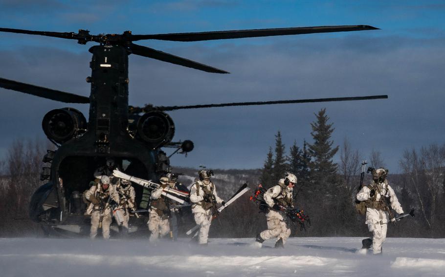 Soldiers from the 10th Special Forces Group and Danish special operators move through the woods to call in fire for HIMARS artillery during training at Fort Wainwright. (