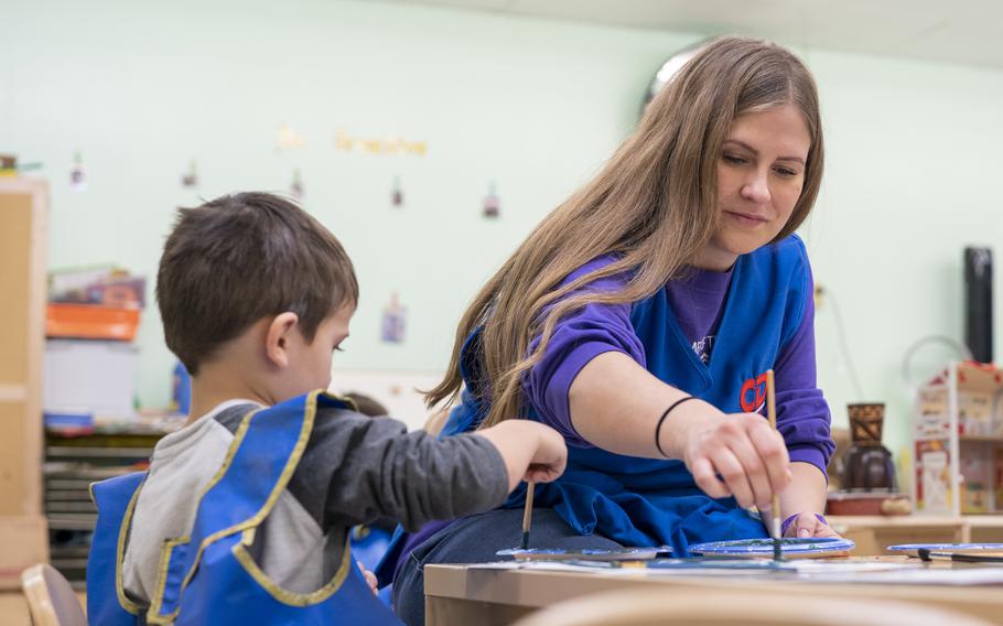 Samantha Meyer paints with a child in the Denali Child Development Center at Joint Base Elmendorf-Richardson, Alaska, Oct. 20, 2023. Military families have until Dec. 11 to enroll in a new program that allows them to set aside up to $5,000 tax-free for child care and other dependent care programs.