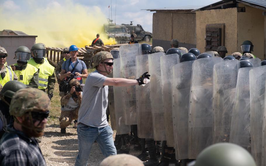 Simulated Molotov cocktails are used against incoming forces during the Operation Bronze Shield training exercise June 14, 2023, at the Joint Multinational Training Center in Hohenfels, Germany. Once the simulated firebomb was thrown, it would be replaced with a smoke grenade until riot control could put out the fire.