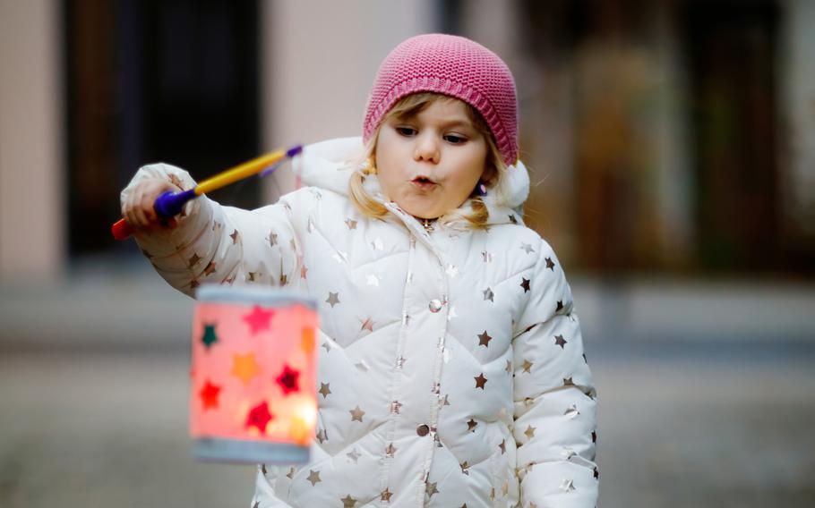 A small girl holds a homemade lantern during a St. Martin procession in Germany. 