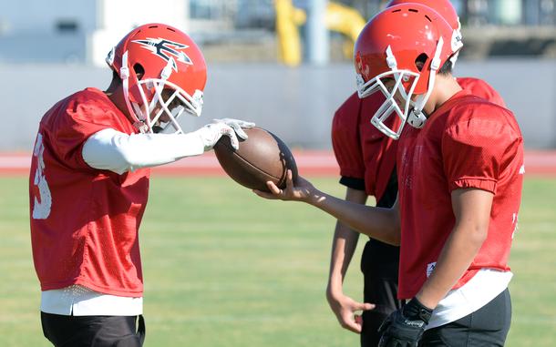 Junior Jacob Bojorquiz, left, and sophomore Dylan Kim try to keep a hand on the ball during a Kinnick ball-security drill.