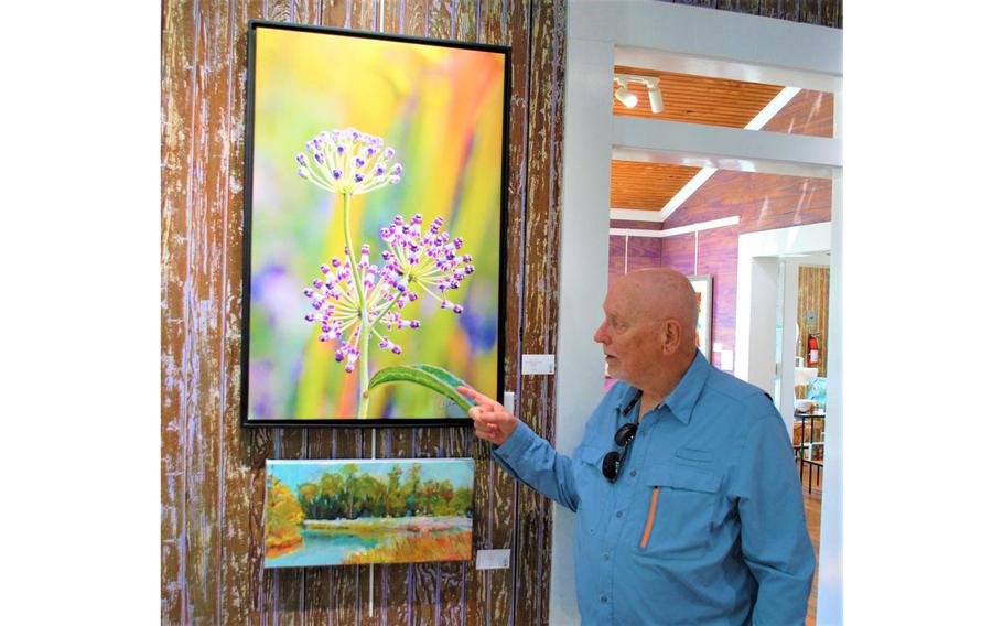Ocean Springs, Miss., photographer and Vietnam veteran Charlie Taylor with one of his prints inside My Happy Place Gallery in downtown Ocean Springs.