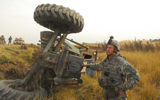 Muqdadiya, Iraq, Dec. 7, 2006:  Spc. David Flowers, 31, of Baltimore and the 15th Engineer Company, stands beside an upturned road grader moments after he tumbled down an embankment inside the piece of heavy equipment during a route sanitation mission near Muqdadiya in north central Iraq.

Read the story and check out more photographs here. https://www.stripes.com/news/danger-lurks-in-the-roadside-debris-army-engineers-are-tasked-with-clearing-in-iraq-1.57798