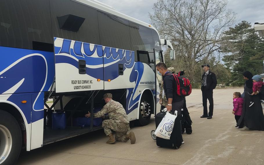 Soldiers help Afghan families load their luggage on a bus out of Fort McCoy, Wis., Oct. 11, 2021. They were among the first to leave the base and begin the journeys to their new hometowns.