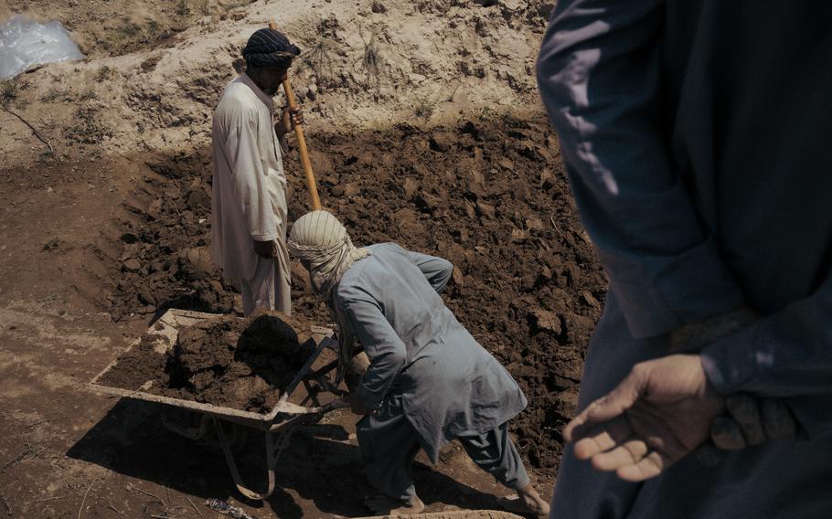 Workers collect mud to build a wall in the village of Qultagh in Dawlatabad. In this village, the water from the wells is too acidic and salty because of depletion of water resources in the area. 