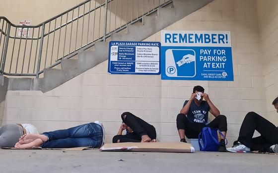 A group of migrants, the majority coming from Venezuela, attempt to rest in a parking garage after being released by Customs and Border Protection agents, in Brownsville, Texas, on May 6, 2023. - Migrants crossed the Rio Grande and surrendered to Customs and Border Patrol agents a few days ago. Then they were taken to a detention center and released on American soil, where they are free to remain while a migration judge reviews their cases. Some of them are waiting for another relative to be released to continue on their way, and others are waiting for a relative that lives in the United States to buy their tickets to continue their trips. Humanitarian organizations say that there was an important increase in migrants in the last month, from 200 to 700 daily, because they are afraid that after the end of Title 42, they could be deported to their original countries or banned to enter the US for several years. Moisés Avila/AFP via Getty Images/TNS)