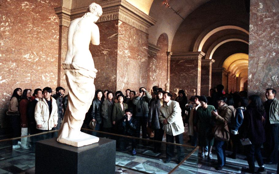 Tourists gather around the Venus de Milo at the Louvre in Paris.