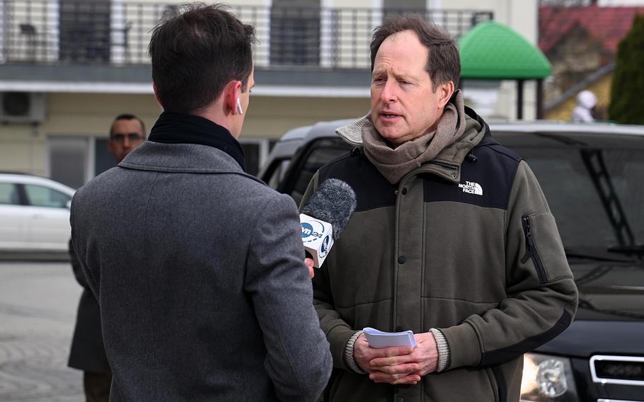 Mark Brzezinski, the U.S. ambassador to Poland, right, talks to a Polish television reporter Feb. 25, 2022, in Przemysl, Poland, outside a hotel where the embassy has set up a welcome center for Americans leaving Ukraine.