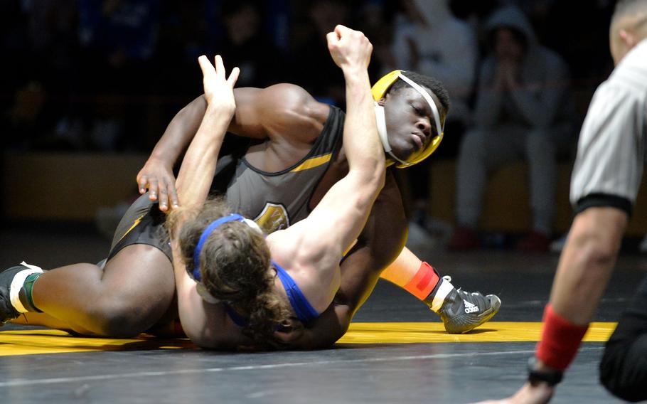 Daniel Bagoudou, top, won the 215-pound title at the DODEA-Europe wrestling championships, in Wiesbaden, Germany, Feb. 11, 2023, defeating Ramstein’s Evan Brooks.