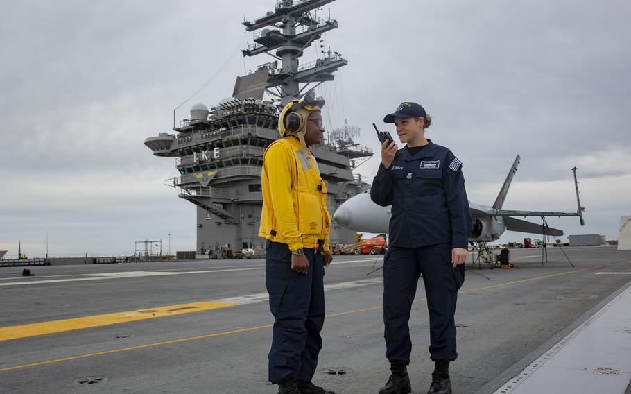 Petty Officer 1st Class Kelly Pyron, assigned to U.S. Fleet Forces Command, and Seaman Whitney Gaines, an aviation boatswain's mate, assigned to the aircraft carrier USS Dwight D. Eisenhower, wear the flame-resistant, two-piece organizational clothing prototype on the ship's flight deck in 2019.  