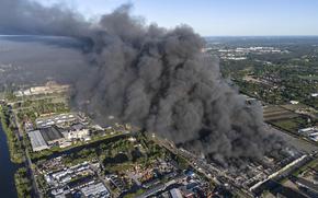 Black smoke rises into the sky above the shopping center.