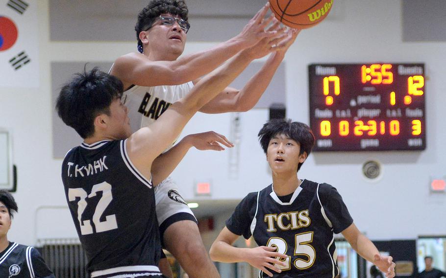 Humphreys' Bryan Gomez skies between two Taejon Christian defenders to shoot during Wednesday's Korea boys basketball game. The Blackhawks won 93-70.