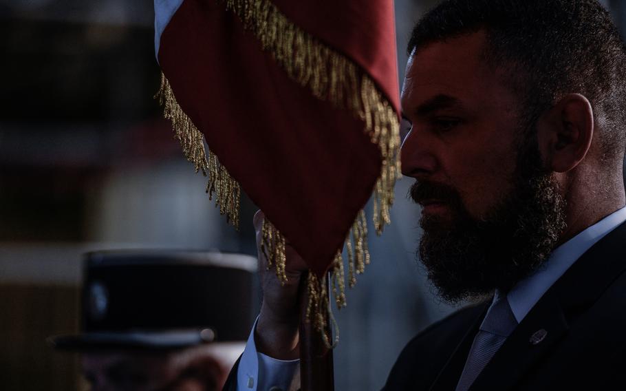 A veteran member of the Society of the Honor Guard, Tomb of the Unknown Soldier, presents colors at the Tomb of the Unknown Soldier at the Arc de Triomphe, in Paris, Oct. 26, 2021. The U.S. society includes current and former tomb guards who served at Arlington National Cemetery.