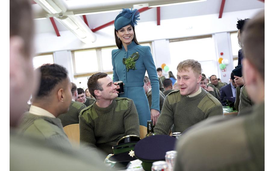 Britain’s Catherine, Princess of Wales holds a half-pint of Guinness as she meets with members of the 1st Battalion Irish Guards following their St Patrick’s Day Parade at Mons Barracks in Aldershot, south west of London, on March 17, 2023. 