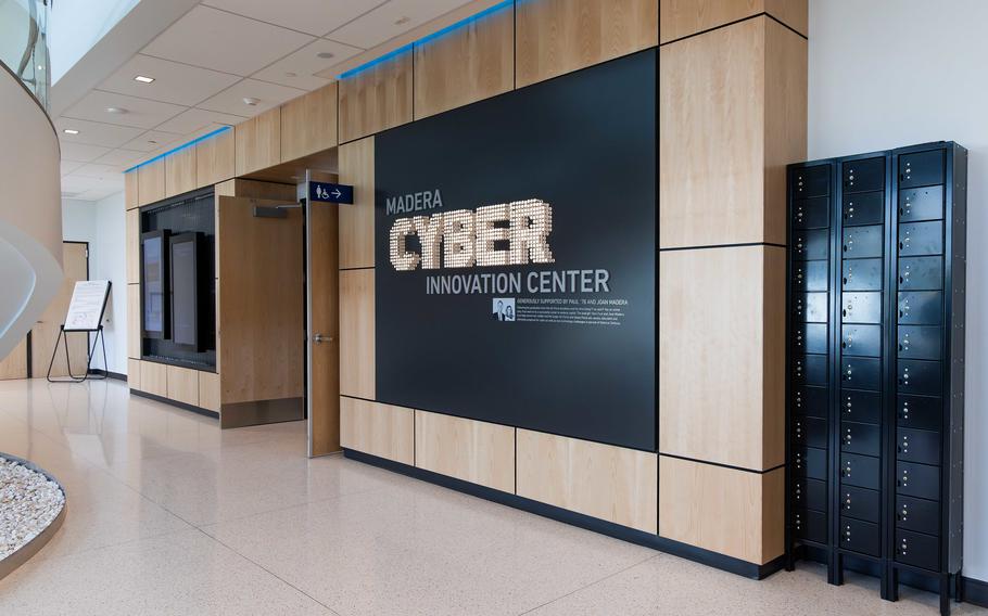 A wall with a black screen reading “MADERA CYBER INNOVATION CENTER.”