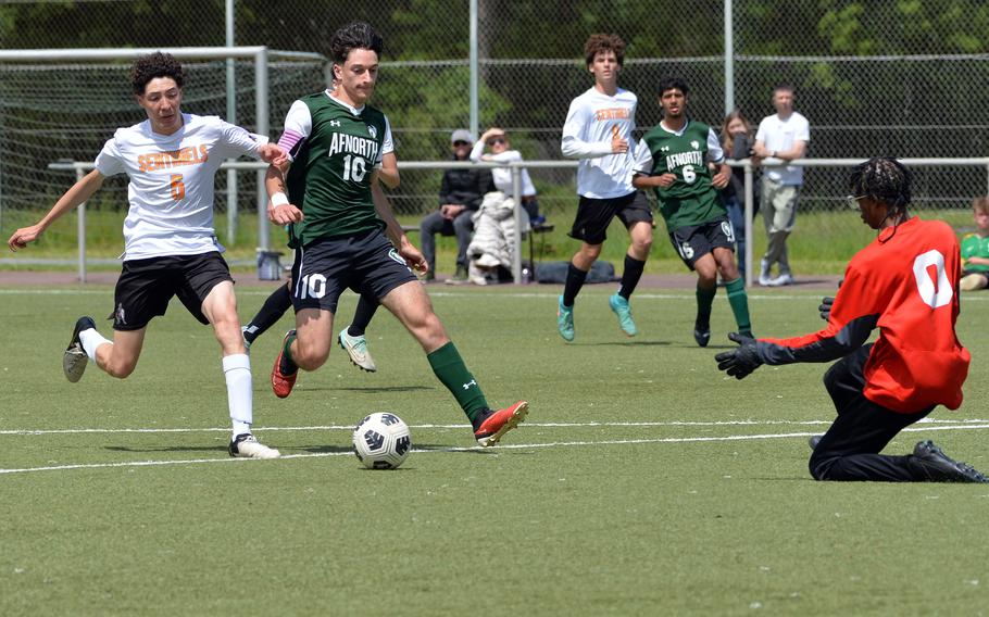 AFNORTH’s Christian Barone gets past Spangdahlem’s Mason Tieyah for a shot on goal as Sentinel keeper Isaiah waits to make the save. The Lions beat Spangdahlem 4-0 in a Division III semifinal at the DODEA-Europe soccer finals in Landstuhl, Germany, May 22, 2024, to advance to Thursday’s final against Ansbach.