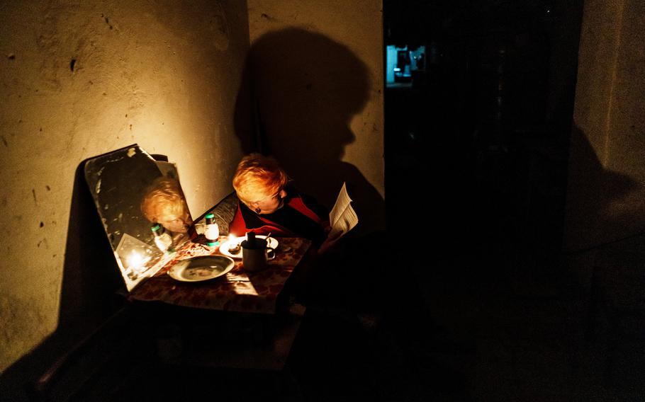 A woman reads a book underground as war rages on above ground in Lysychansk, Ukraine, Monday June 13, 2022. 