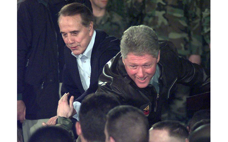 President Bill Clinton and his opponent in the previous year's election, former Sen. Bob Dole, meet American servicemembers at Eagle Base, Bosnia and Herzegovina, on Dec. 22, 1997.