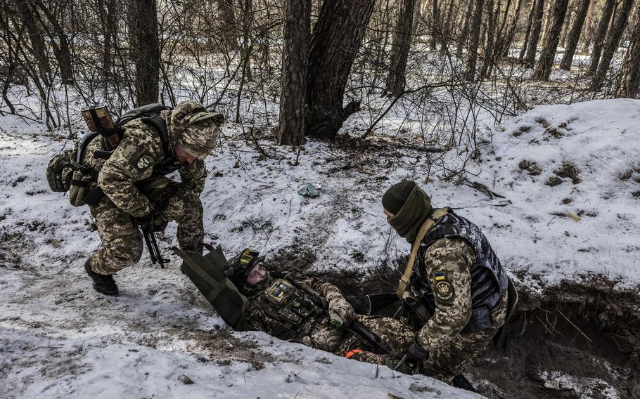 Soldiers practice evacuating a wounded comrade from a trench. 