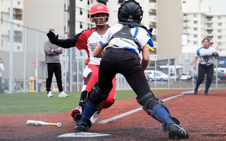 Yokota's Abbie Vernon squares up against Kinnick's Tristan Hatcher as the two prepare to collide at home plate during Saturday's DODEA-Japan softball game. Hatcher would be called out. The Panthers won 14-7.