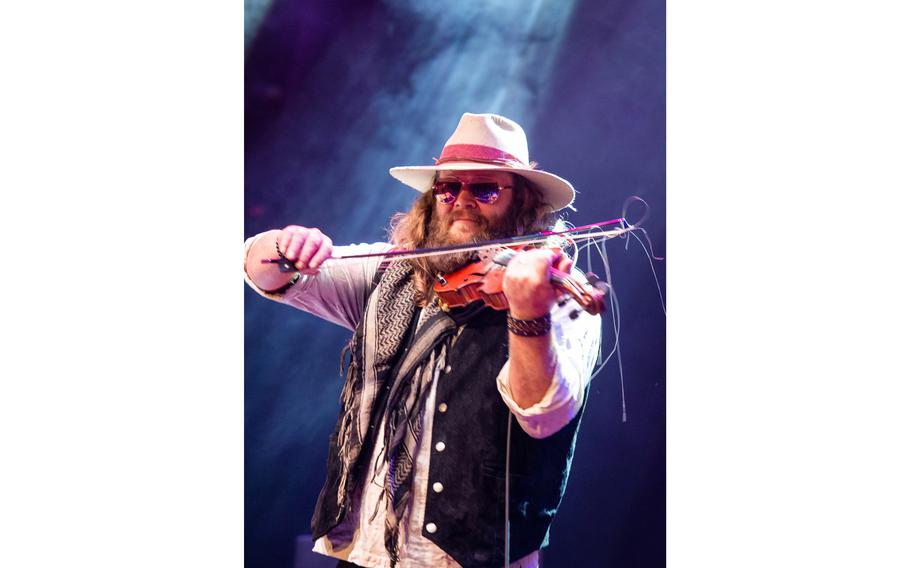 Army veteran Donnie Reis plays violin with the War Hippies country duo on March 9, 2023, during a concert at MadLife Stage & Studios in Woodstock, Ga., just north of Atlanta.