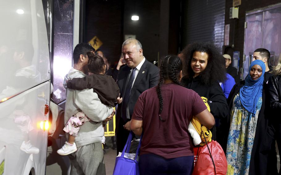 New York City Mayor’s Office of Immigrant Affairs Commissioner Manuel Castro, center, welcomes migrants arriving at the Port Authority Bus Terminal, Wednesday, May 3, 2023. 