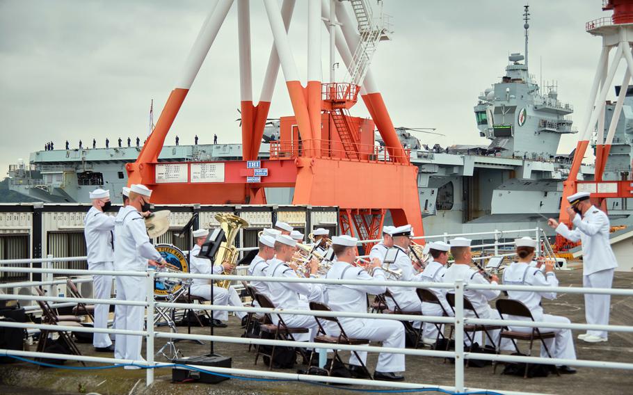 The 7th Fleet Band performs festive music as the Royal Navy aircraft carrier HMS Queen Elizabeth arrives at Yokosuka Naval Base, Japan, Saturday, Sept. 4, 2021. 