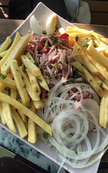 A wurst salad with french fries is served for dinner on Friday, July 8, 2022, by Kunst Cafe at Vogelwoog Park in Kaiserslautern, Germany.