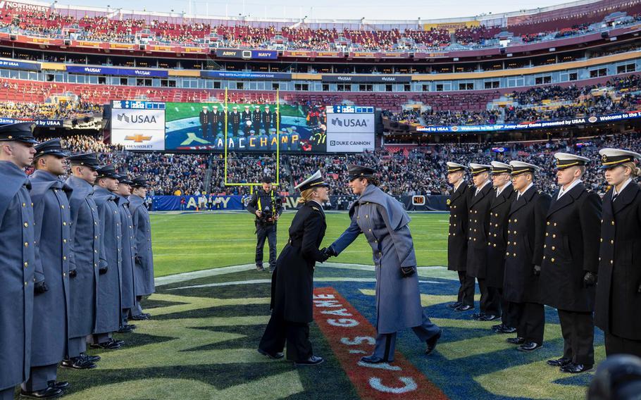 A Navy midshipmen and an Army cadet shake hands before the game.