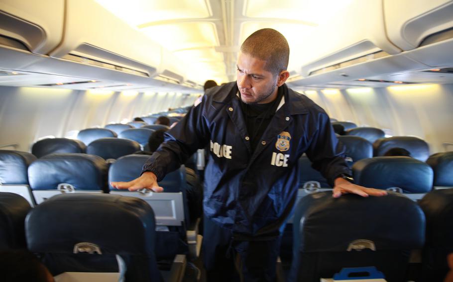 An U.S. Immigration and Customs Enforcement officer patrols a removal flight.